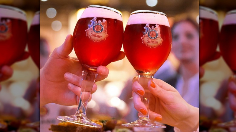 Hands clinking Paulaner Salvator glasses together