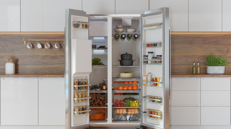 Open double-door refrigerator alongside a modern kitchen interior