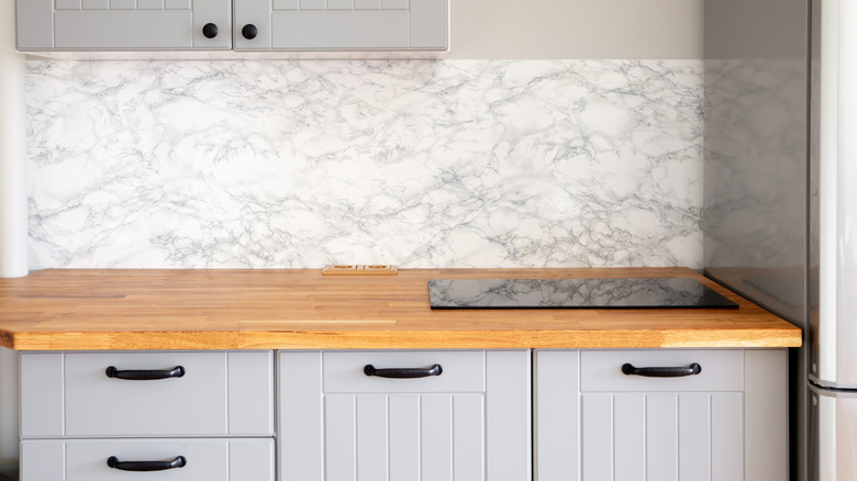 Minimal grey kitchen with a butcher block countertop