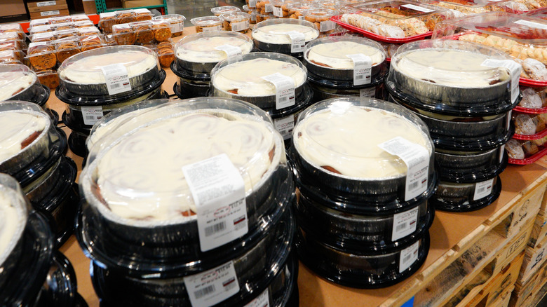 Plastic trays of Costco cinnamon rolls displayed in a store