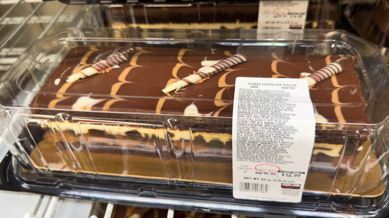 Costco tuxedo cake with chocolate decorations in a plastic packaging