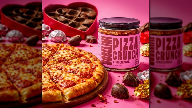 Jar of Sobelini Pizza Crunch on pink surface next to pizza and chocolates