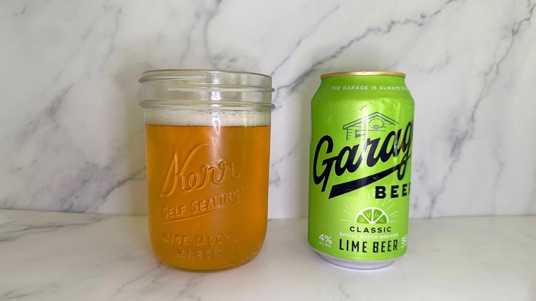 Can of Garage Beer Lime next to glass of beer on marble surface