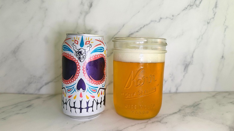 Can of Stone Brewing Buenaveza Salt & Lime Lager next to glass of beer on marble surface