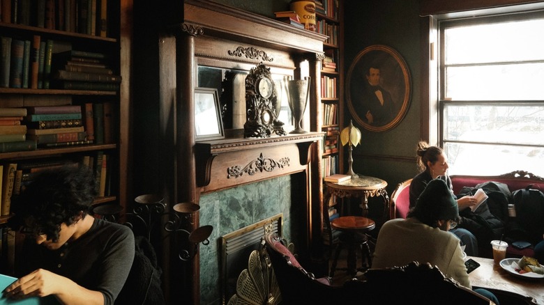 People reading and working in café filled with books and antiques