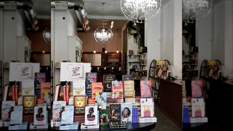 Table laden with books, wine bar in background