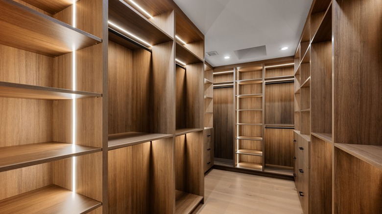 Room-sized custom walk-in closet with wooden shelves