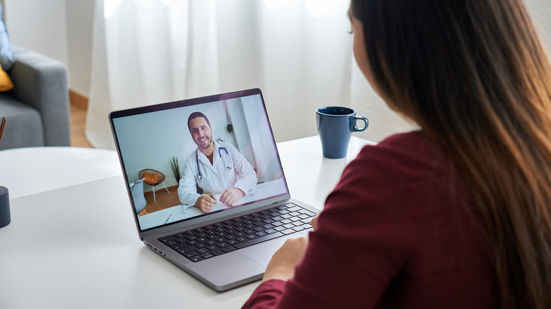 Woman having a virtual doctors visit via her laptop screen