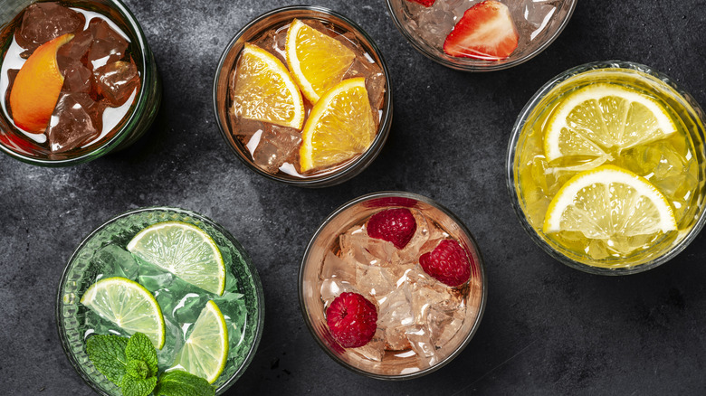 aerial view of several fruity drinks filled with ice in glasses