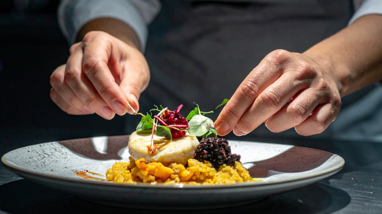 A chef plating a gourmet dish on a counter