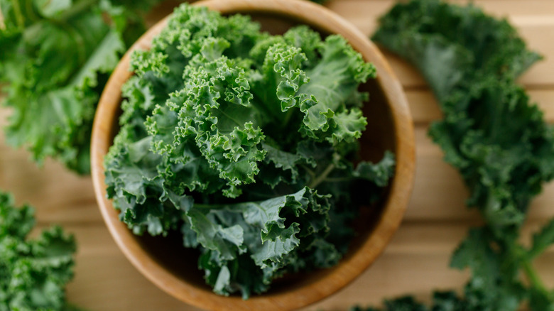 Top view of a bunch of fresh kale in a clay bowl