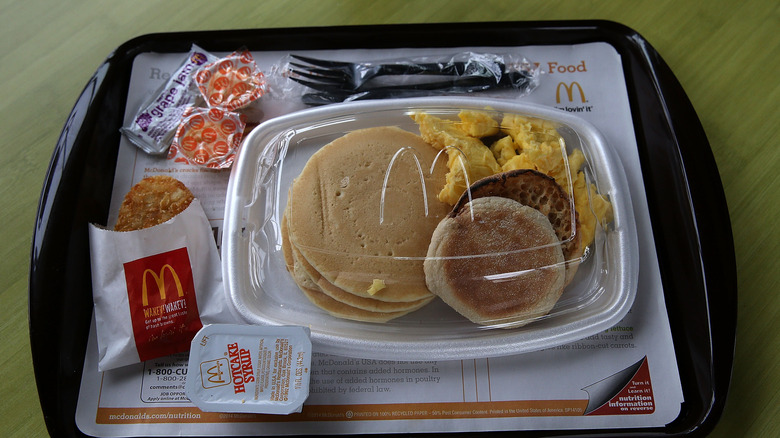 Tray of McDonald's Big Breakfast with hotcakes, muffin, scrambled eggs, and hash brown