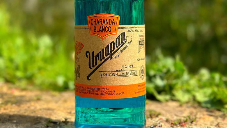 Close-up shot of Charanda Uruapan label against out of focus green background.