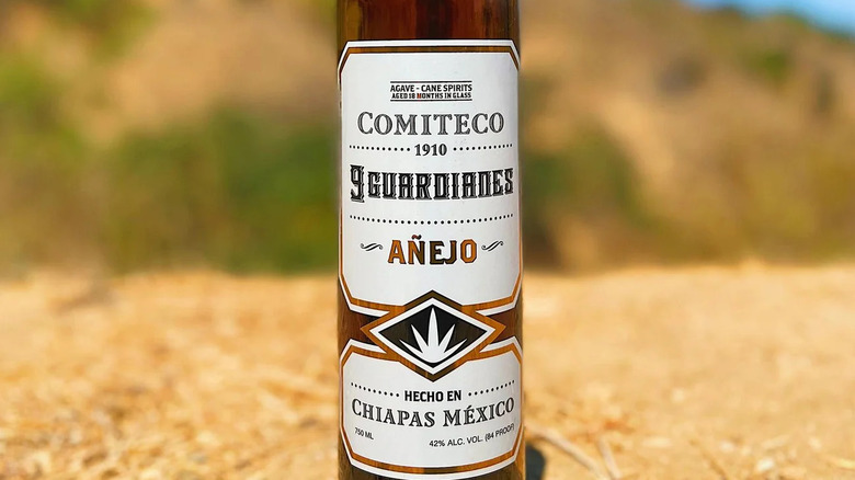Close-up of Comiteco bottle label against out of focus yellow background.