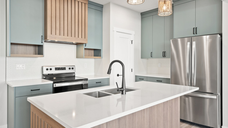 A stylish kitchen with mint green cabinets
