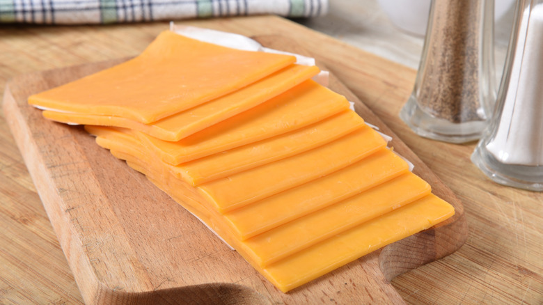 Thick cheese slices on wooden board
