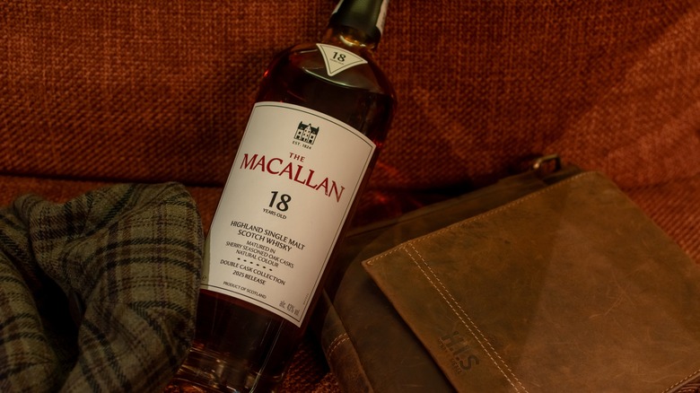 A bottle of The Macallan 18-year laid down on furniture, highlighting a bottle that has premium pricing