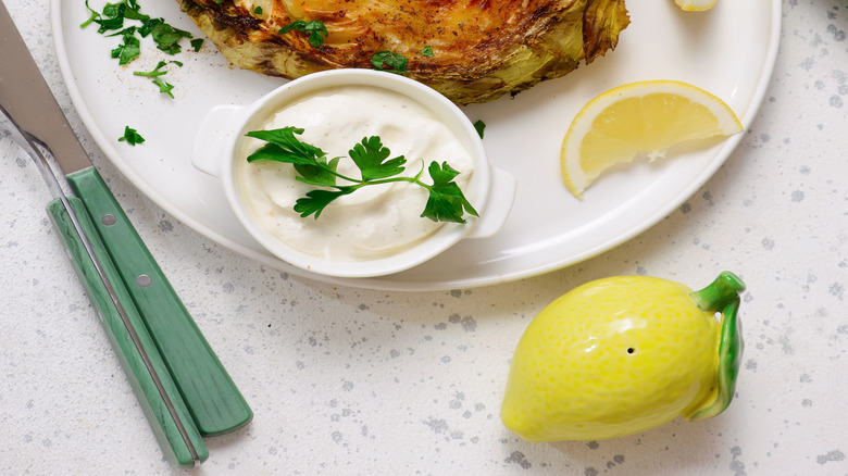 A slice of browned cabbage steak on a white plate