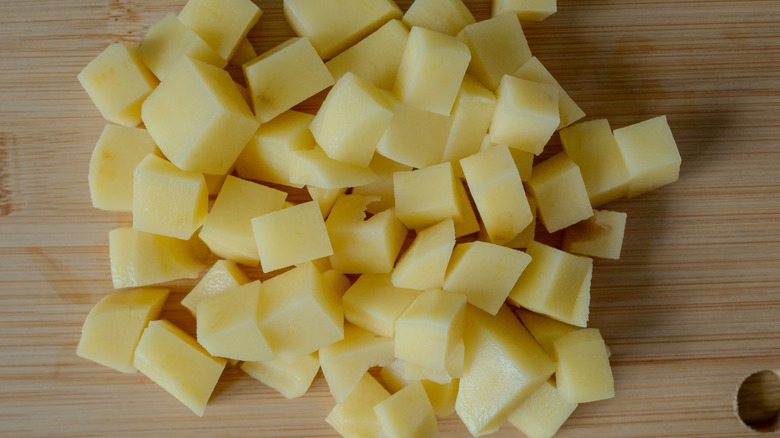 Chopped potatoes on wooden cutting board
