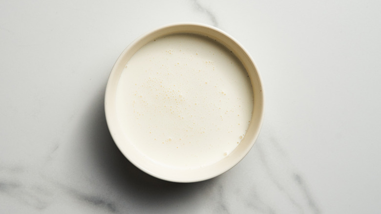 Heavy cream in white bowl on countertop