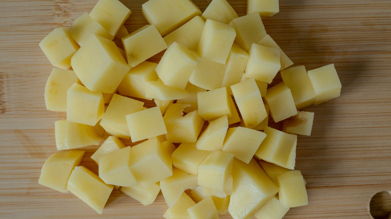 Chopped potatoes on wooden cutting board