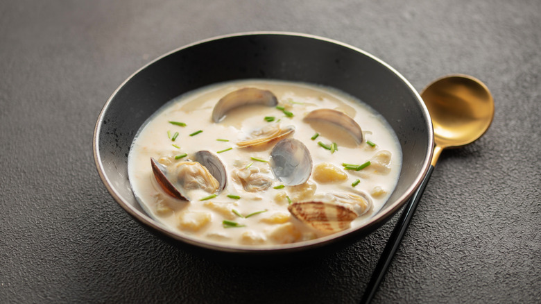 Clam chowder in grey bowl with gold spoon
