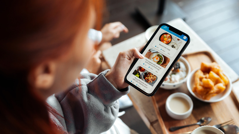 Person holding phone ordering from food delivery app