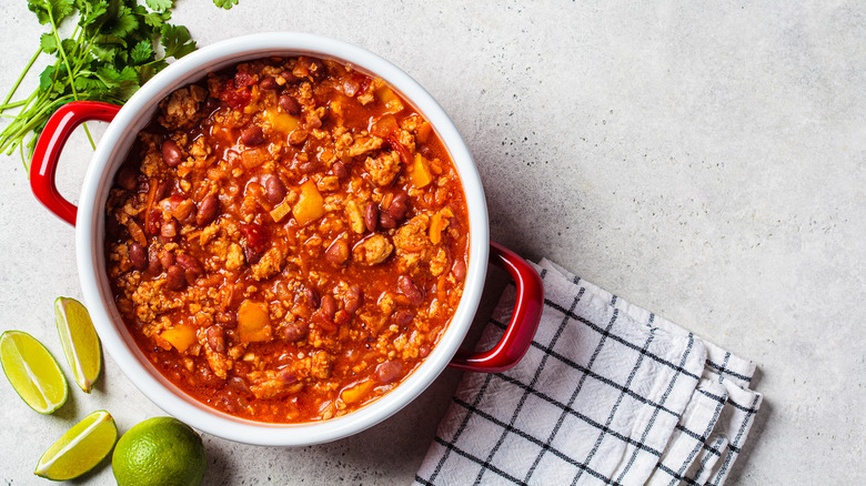 Chili on red and white pot on white countertop