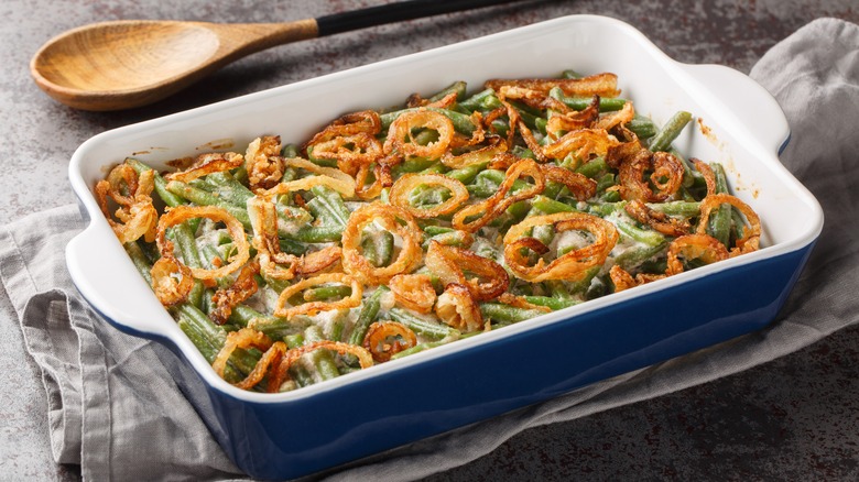 Green bean casserole in blue casserole dish on towel