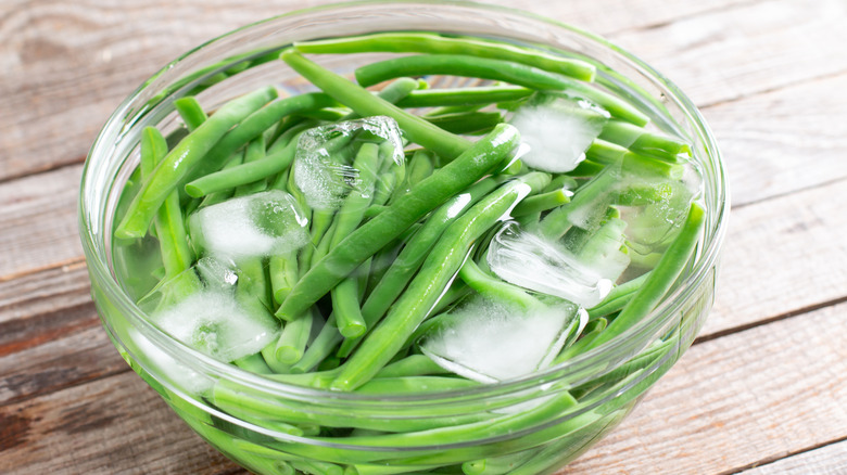 Green beans in ice bath in glass bowl