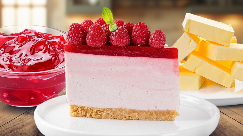 A slice of rasberry cheesecake in the center with jam and butter alongside it