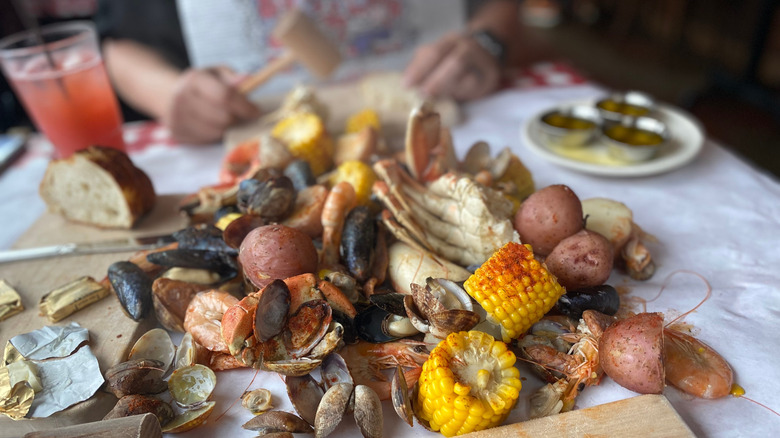 seafood boil spread on a table with condiments on the side