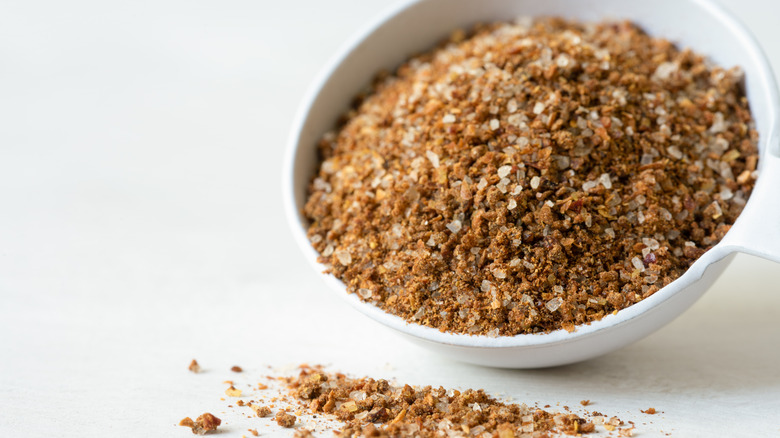 Cajun spices spilling from a teaspoon