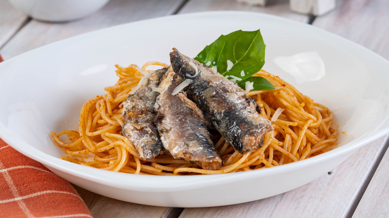 Bowl of tomato spaghetti topped with tinned sardines
