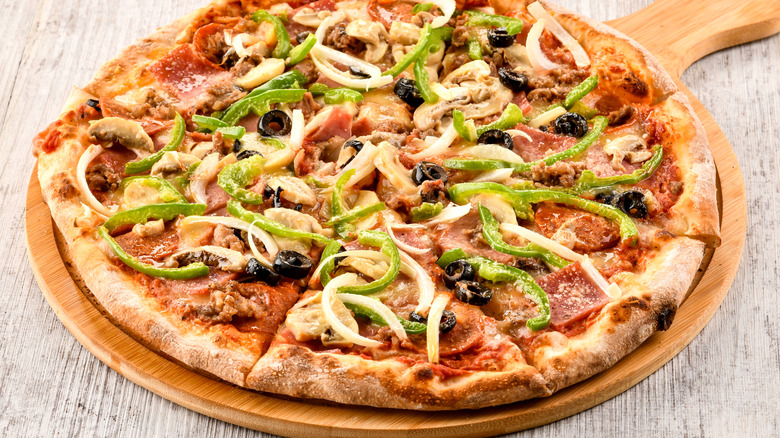 Supreme pizza on wooden board