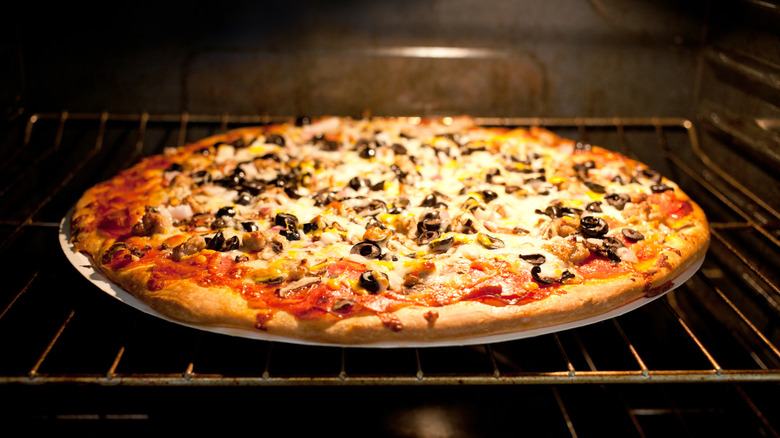 Pizza on pan in oven at home