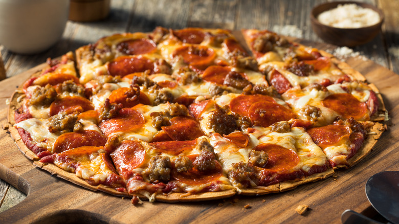 Thin crust pizza cut into squares on wooden board