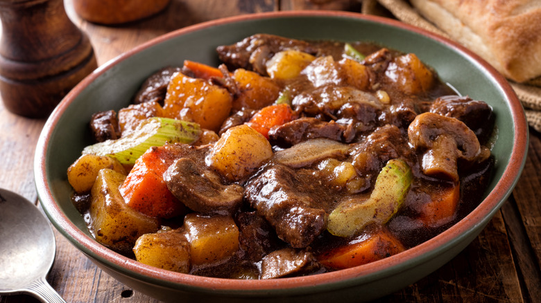 Big bowl of beef stew on wooden table