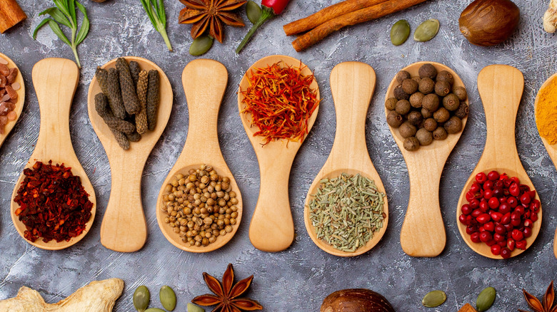 Various spices on wooden spoons
