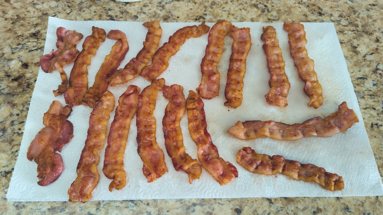 Bacon draining on paper towels on countertop