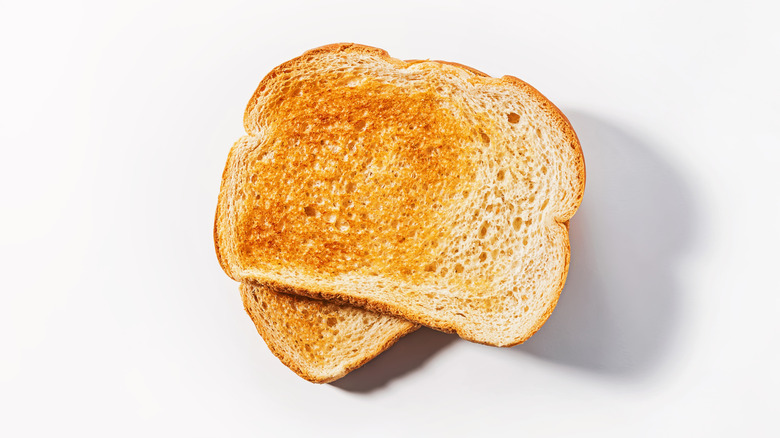 Two slices of toasted white bread on white background