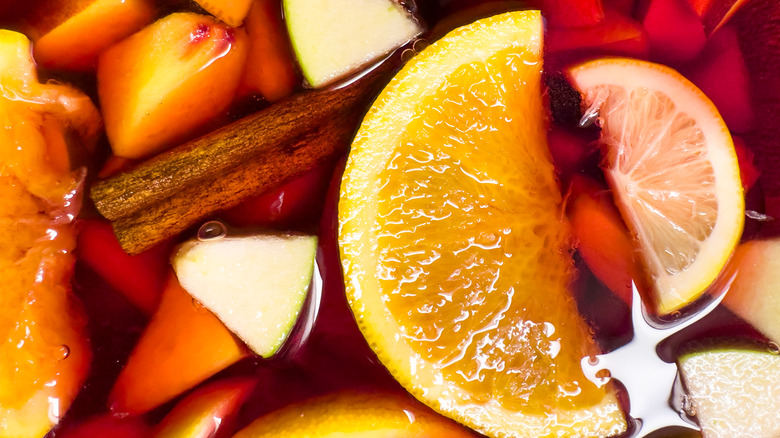 Close up of various spices and fruit in red sangria cocktail