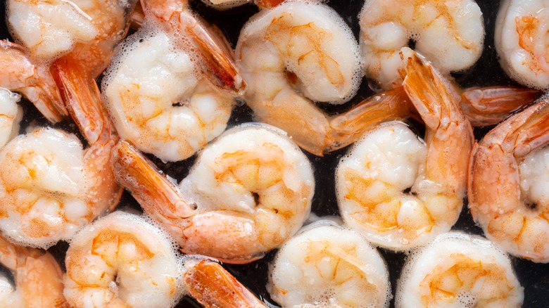 Peeled and deveined shrimp on black background