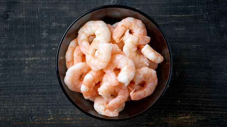 Small shrimp in a bowl on dark wooden background