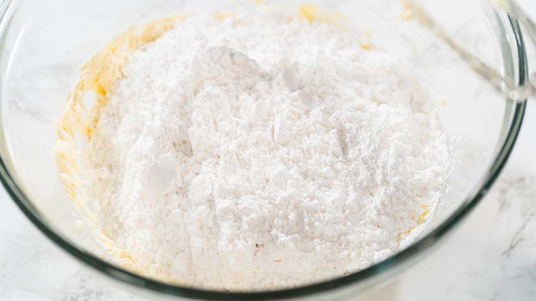 Ingredients for cream cheese frosting in glass bowl