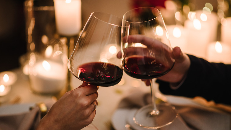 Couple clinking glasses of red wine on a dinner date