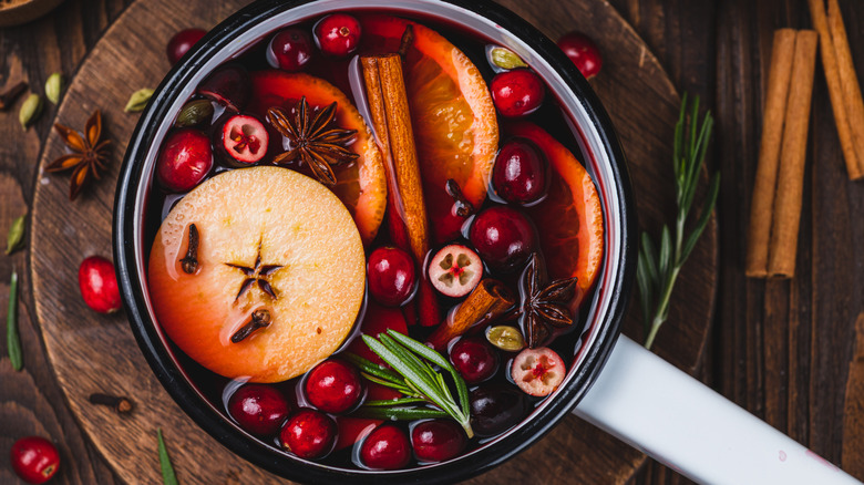 Pot of mulled wine with cranberry, citrus, herbs, and spices