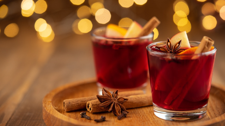 Mulled wine with whole spices in glasses on board