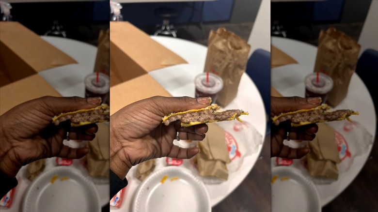 Hand holding Wendy's burger patty