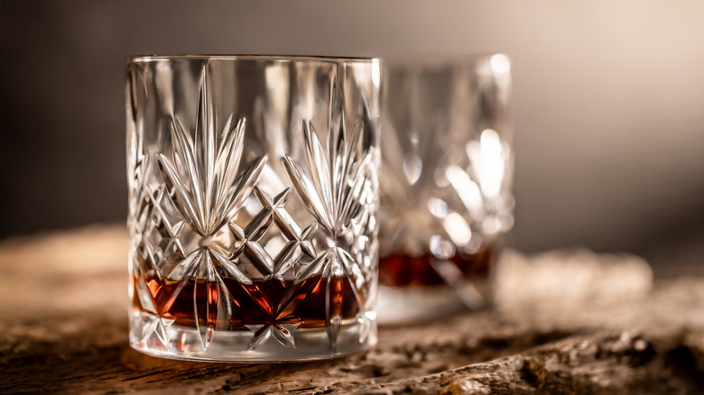 Two glasses of bourbon on wooden table